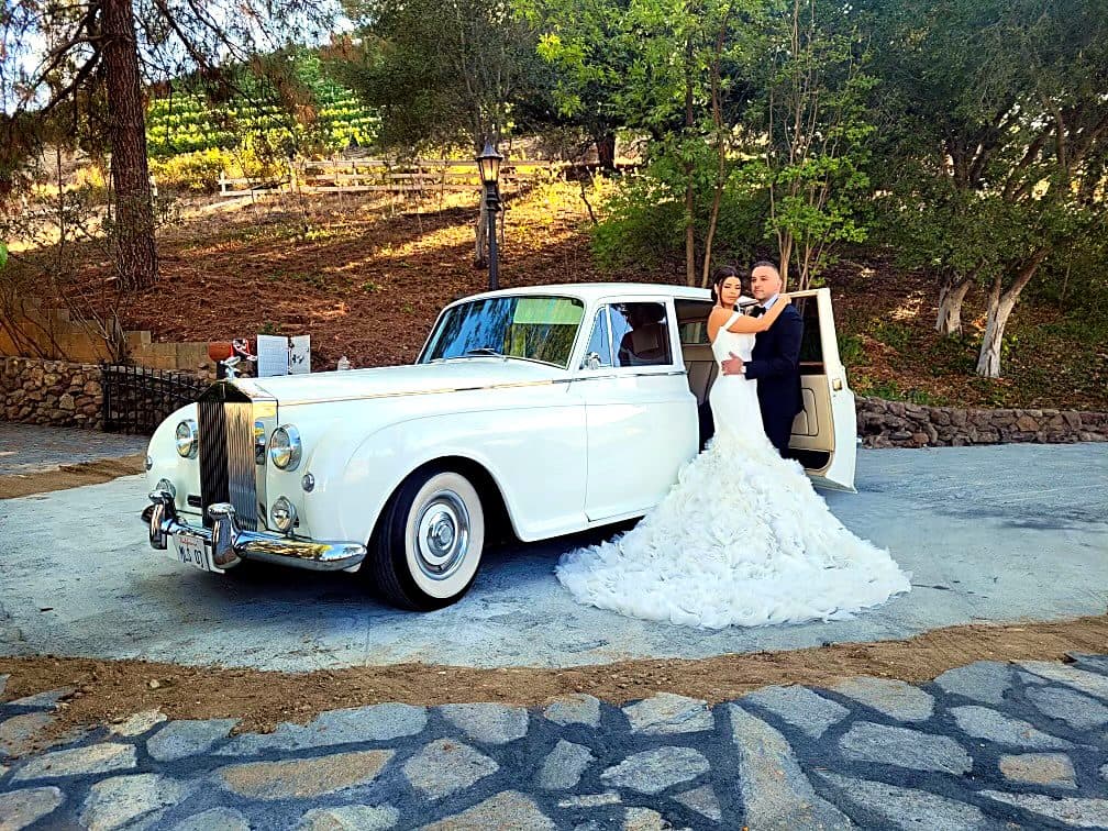 Bride beside a stretched Rolls-Royce wedding limousine